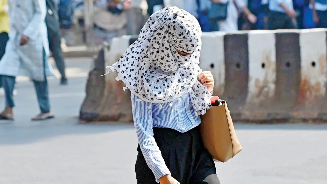 Pedestrians navigate the sweltering afternoon heat along Abdul Rehman Street, opposite Crawford Market (Pic/Sayyed Sameer Abedi) 