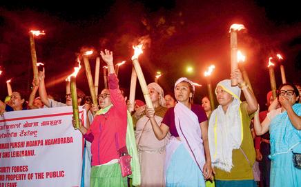 Women hold torches during a rally to protest the attack. Pic/PTI