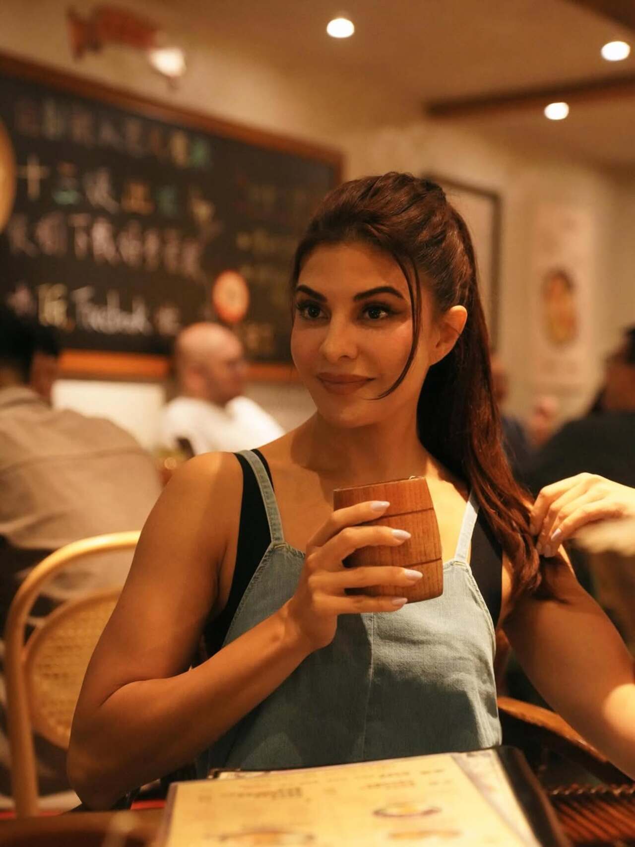 Jacqueline Fernandez in a candid click at a restaurant, looking effortless in a blue outfit while enjoying her meal.
