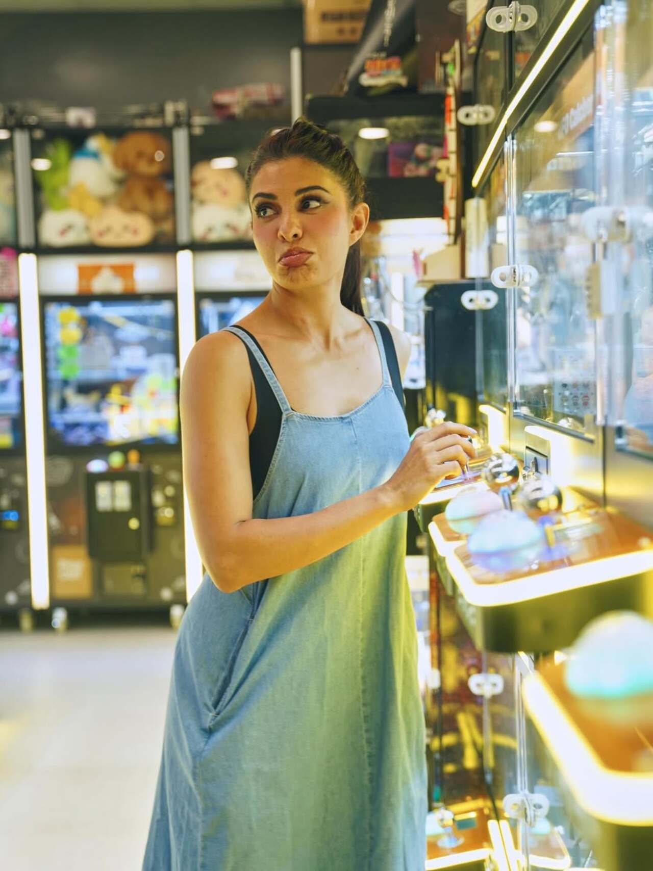 Jacqueline Fernandez strikes a goofy pose in a game zone, embracing her fun-loving side.