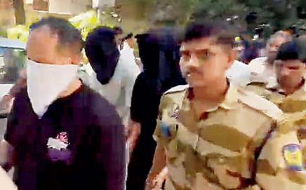 Vineet Gerelani (with face covered) in police custody. Pic/By Special Arrangement