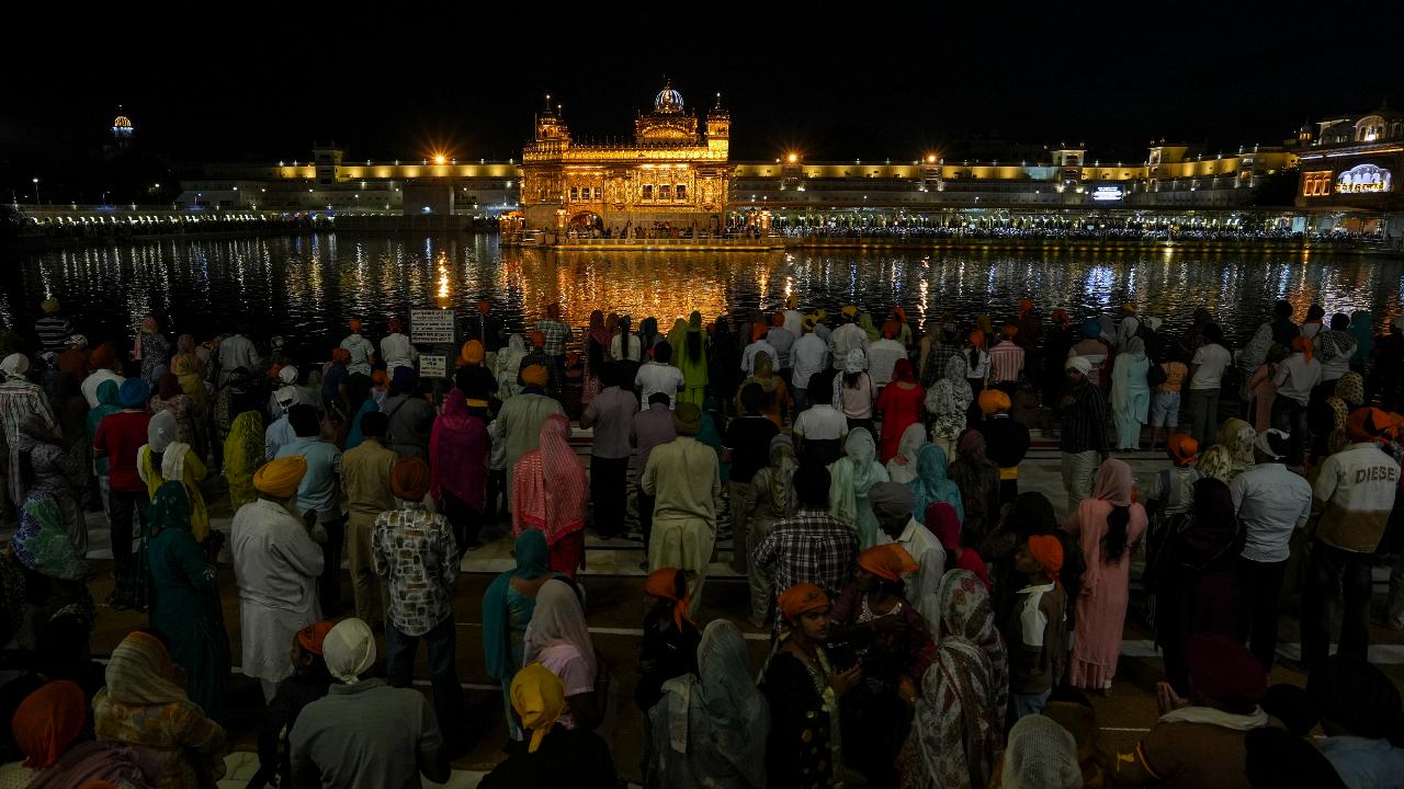 People gather to offer prayers at Golden Temple on the eve of Baisakhi, in Amritsar, Monday, April 13