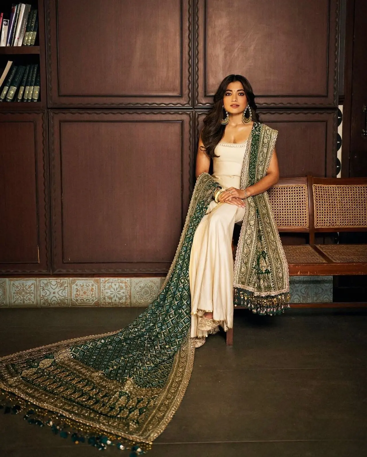 The intricate craftsmanship, statement earrings, and composed posture evoke royal elegance with a contemporary touch