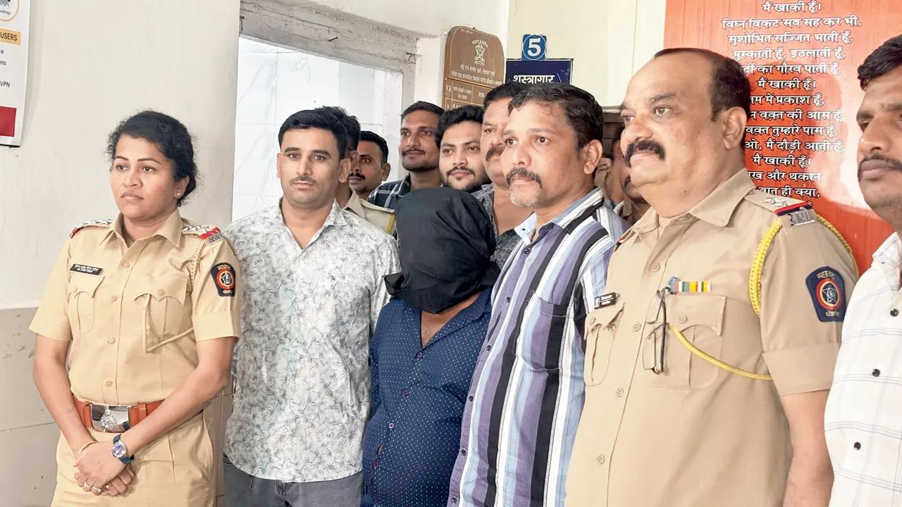 Disabled man dies after being allegedly pushed from moving local train in Mumbai The accused in a hood in the custody of the Bandra Government Railway Police. Pics/By Special Arrangement