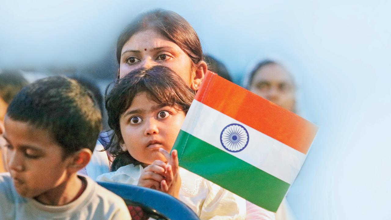 A child holds the national flag while attending a patriotic cultural event in Lucknow. Pic/PTI