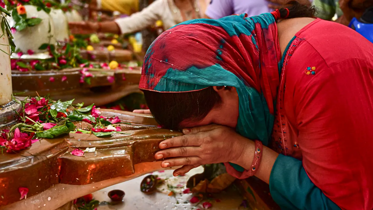 A woman offers prayers on the first 'Monday' of the 'Sawan' month, at a temple in Prayagraj in Uttar Pradesh on Monday. From Bihar and Uttar Pradesh to Rajasthan and Madhya Pradesh, thousands of devotees marked the day with prayer