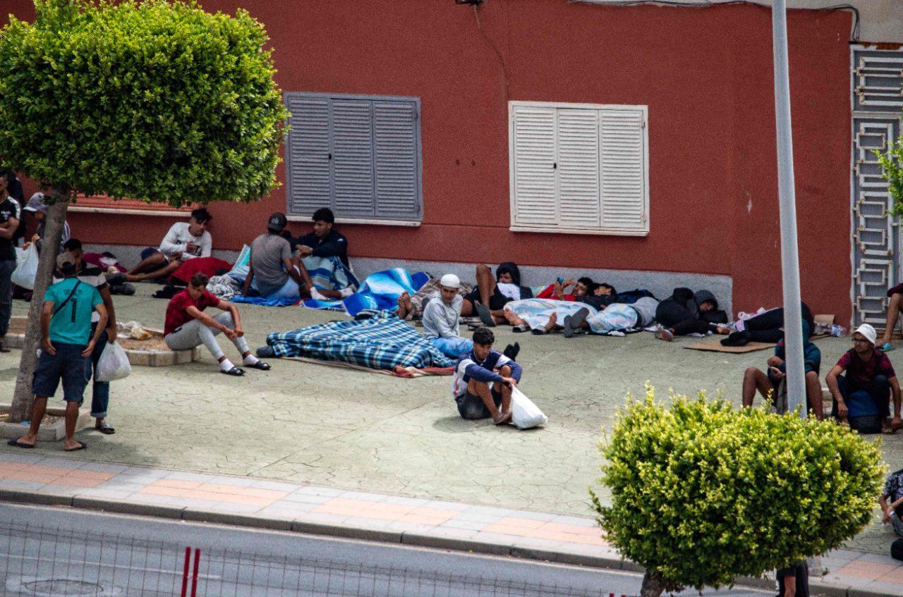 Migrants wait in Ceuta as Spanish authorities work to identify those eligible for asylum and those subject to return to Morocco. Migrants wait in Ceuta as Spanish authorities work to identify those eligible for asylum and those subject to return to Morocco.