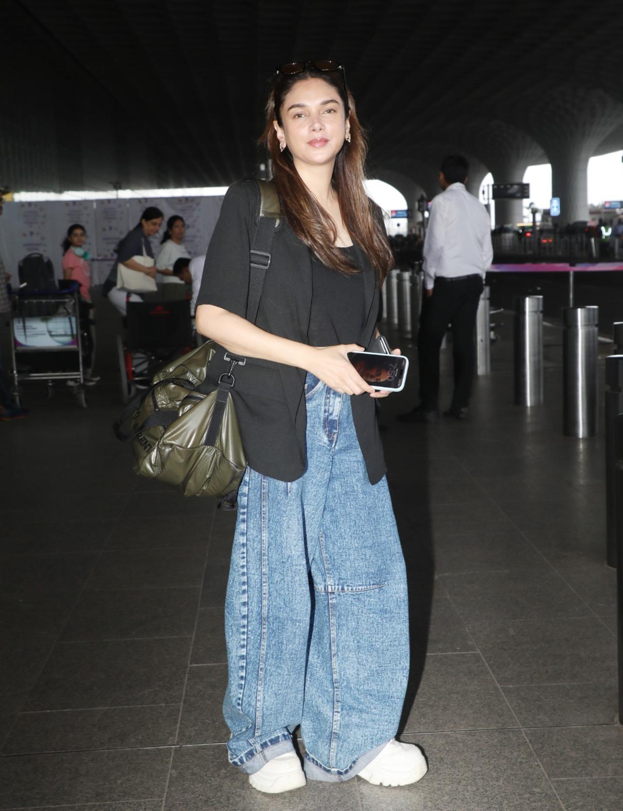 Aditi Rao Hydari exudes sheer charm with her airport look, the diva picks a black blazer to add statement to her denim and tee look. She pairs it with her dewy makeup and sunglasses