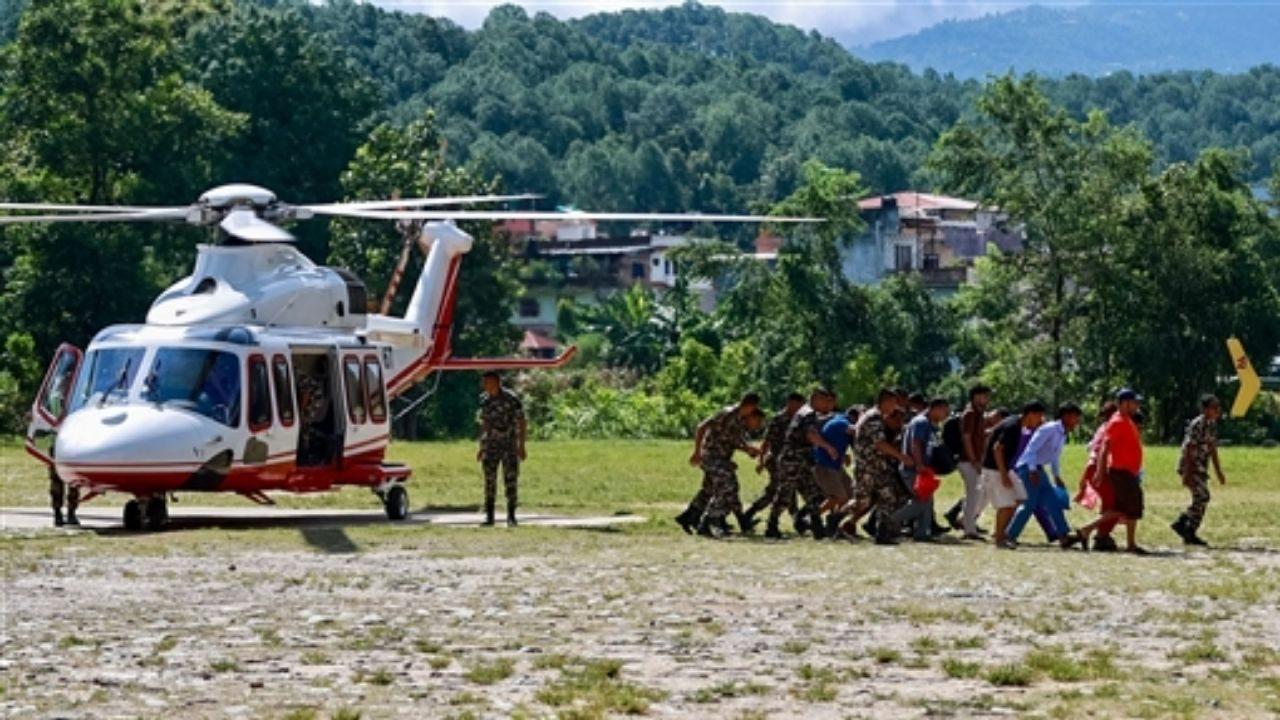 Rescued residents disembark a helicopter at an army camp following flash floods, in Battar Bazar town of Nepal's Nuwakot district Rescued residents disembark a helicopter at an army camp following flash floods, in Battar Bazar town of Nepal's Nuwakot district