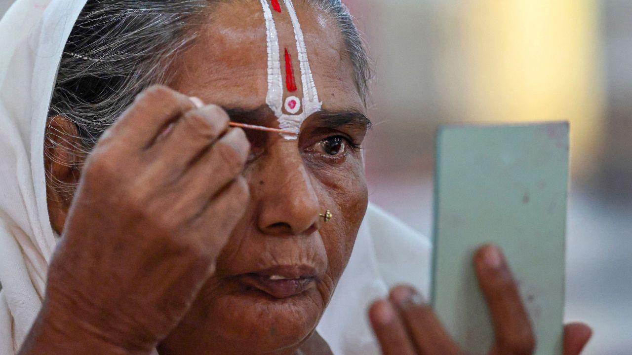 A woman applies 'tilak' as she waits for registration at Ram Mandir base camp amid the ongoing Amarnath Yatra, in Jammu A woman applies 'tilak' as she waits for registration at Ram Mandir base camp amid the ongoing Amarnath Yatra, in Jammu