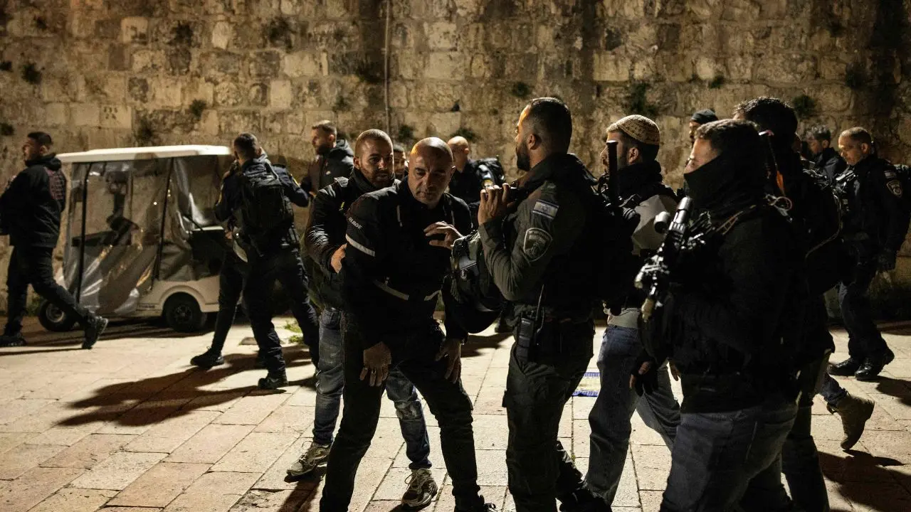 Israeli security forces stop worshippers from entering the Al-Aqsa Mosque compound at the end of the first day of fasting