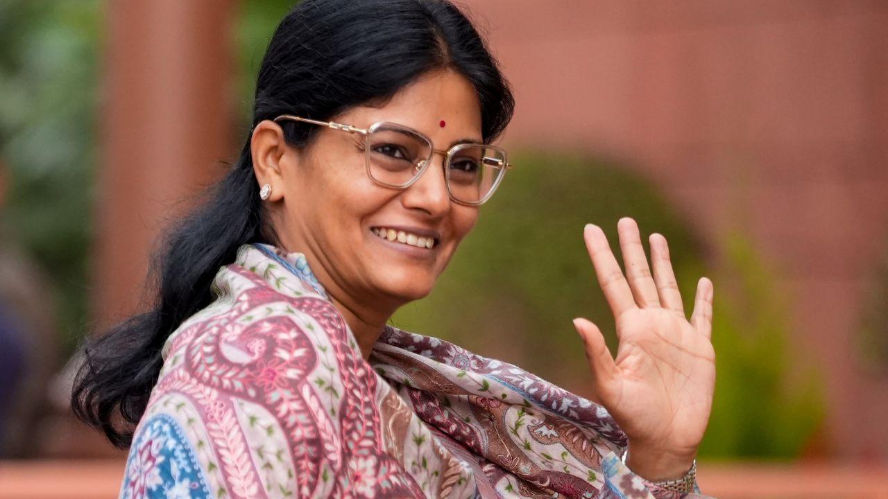 <p>Minister of State Anupriya Patel waves at reporters before stepping into the Parliament</p>