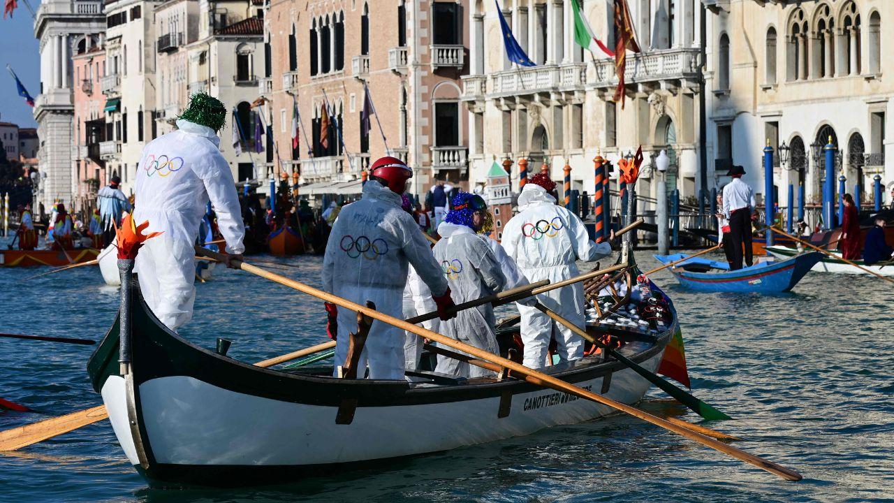 <p>Revellers sail along the Grand Canal in white suits adorned with Olympic Rings, celebrating mythology, sport, and Venice&rsquo;s cultural heritage</p>