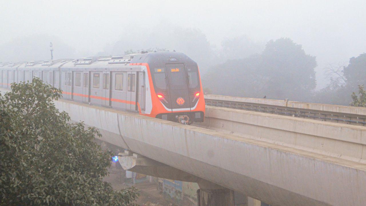 A metro train runs on its tracks during a cold and foggy winter morning in Kanpur