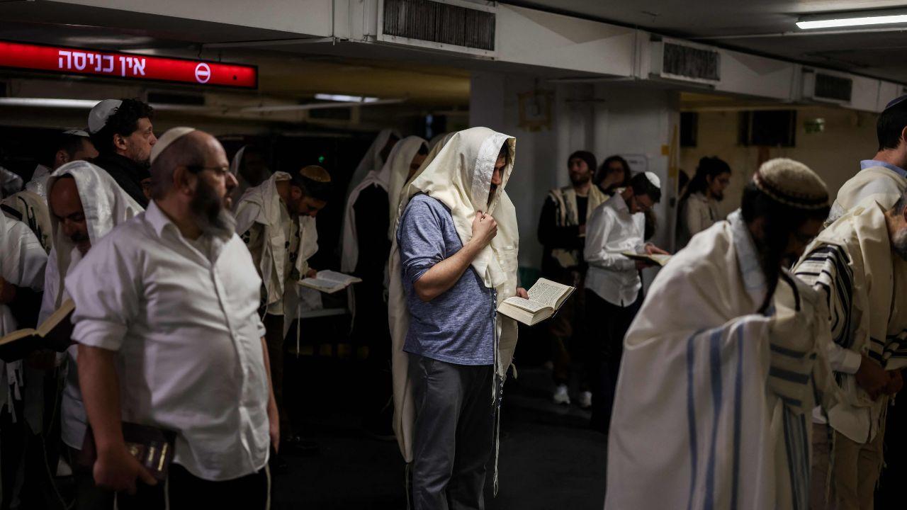 Groups of Jews pray in shelters, showing resilience as sirens echo across the city following preemptive strikes on Iran