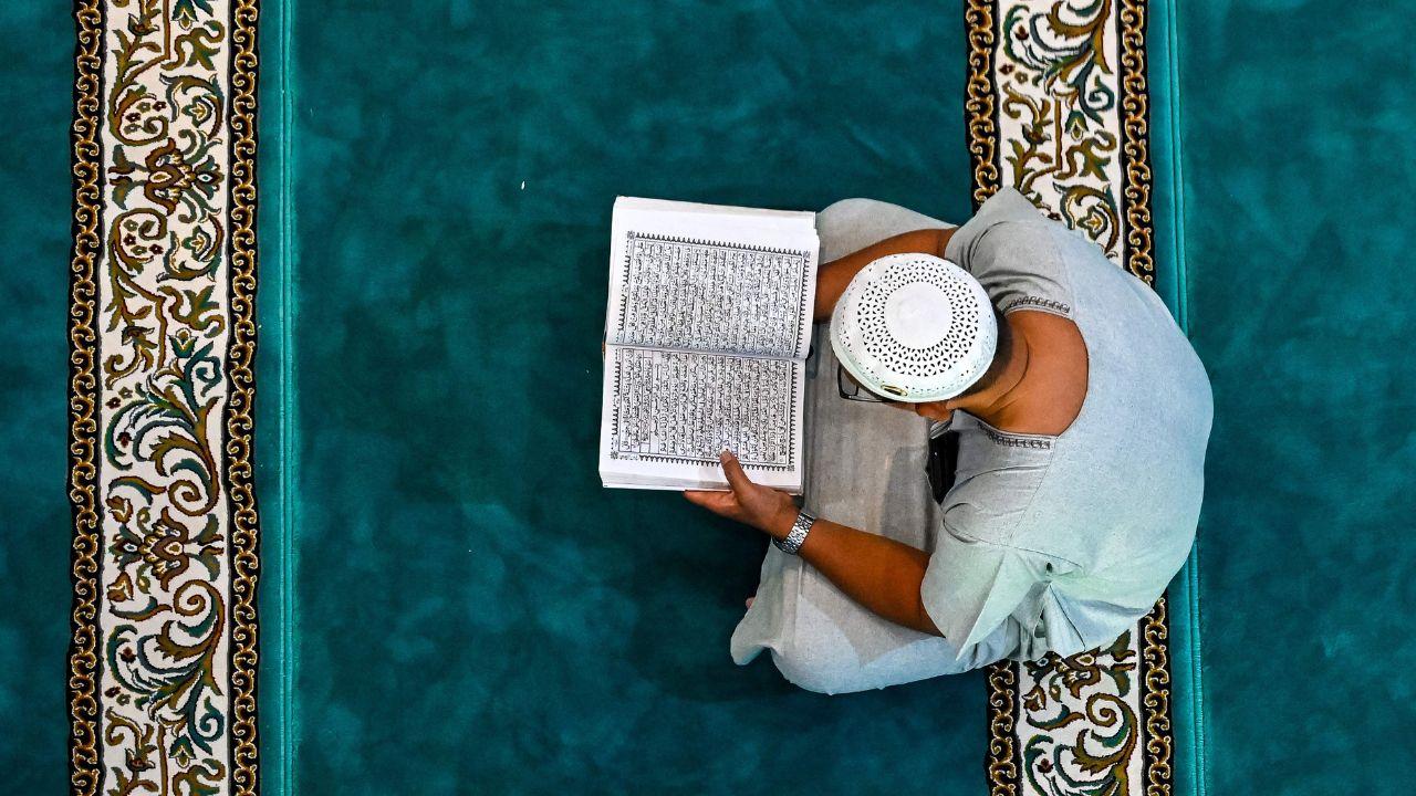 A man concentrates on reading the Koran at the Al Makmur mosque, highlighting the spiritual devotion observed during the holy month in Banda Aceh