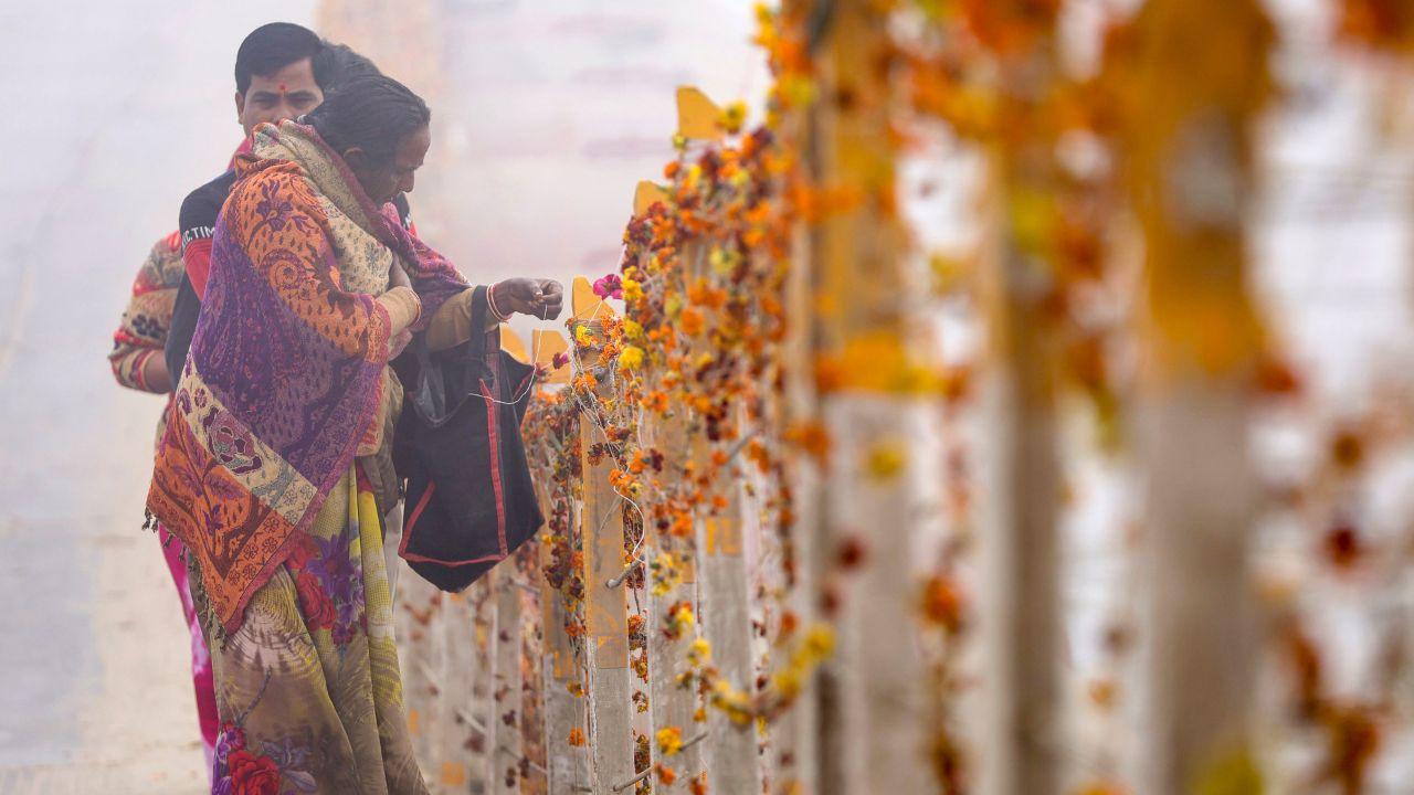 A woman ties a sacred thread during the ongoing 'Magh Mela' festival, in Prayagraj