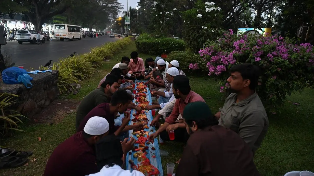The streets around the Videsh Sanchar building, now known as Tata Telecommunications, witness a serene moment as worshippers sit together for iftar, marking the beginning of the holy month
