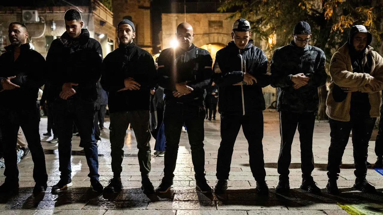 Palestinian Muslims pray outside the Al-Aqsa Mosque after being denied entry, showing devotion despite restrictions