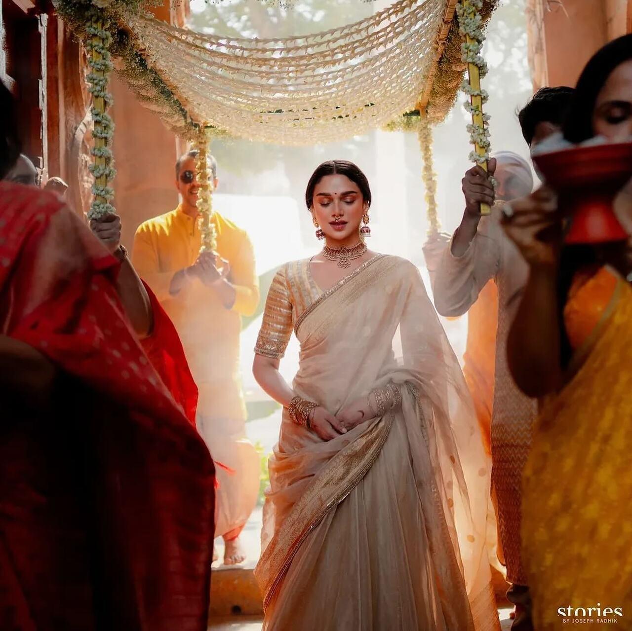 Aditi Rao Hydari stuns as a minimalistic south Indian bride in custom Sabyasachi beige silk saree, simple makeup and gajra-adorned braid. She paired the look with traditional temple jewellery, with polki detailing.