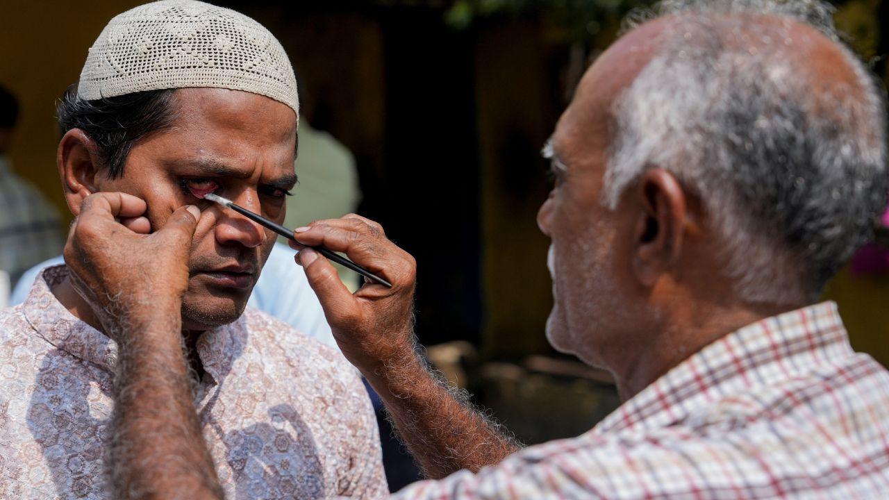 A man applies surma to his eyes before entering a mosque to offer prayers during Ramzan at Tipu Sultan Masjid, in Kolkata