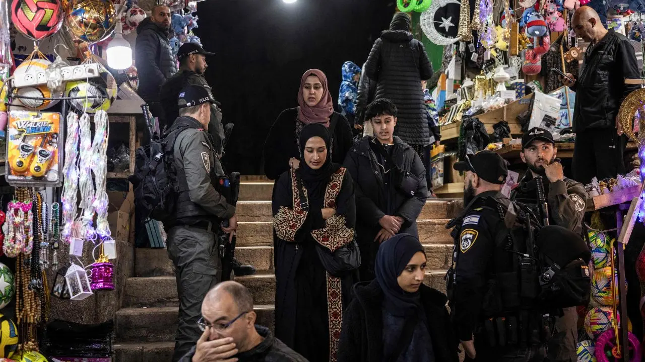 Worshippers leave the mosque compound amid security presence, walking through Jerusalem’s Old City at the end of the first day of Ramadan