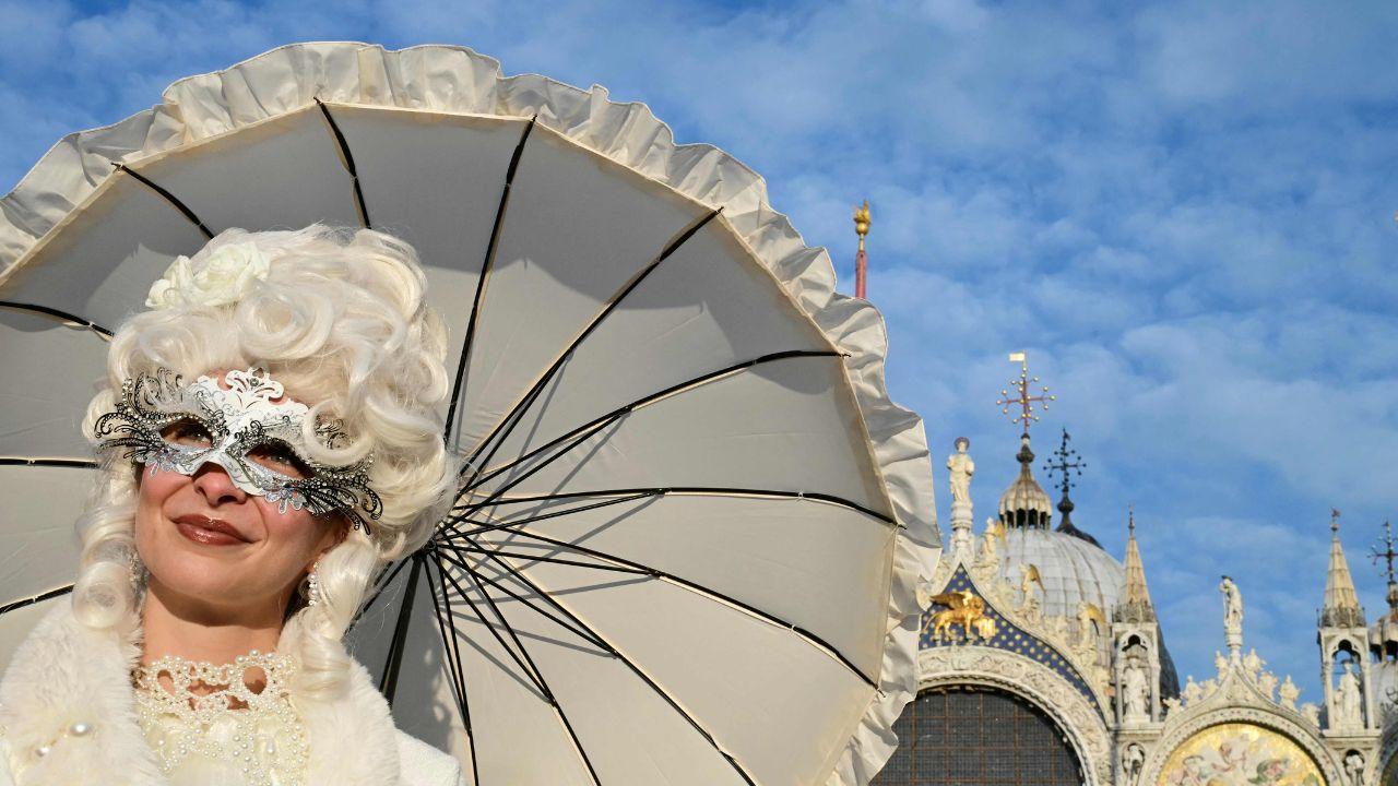 <p>Revellers in elaborate masks pose at St Mark&rsquo;s Square, blending tradition with the spirit of the upcoming 2026 Winter Olympics</p>