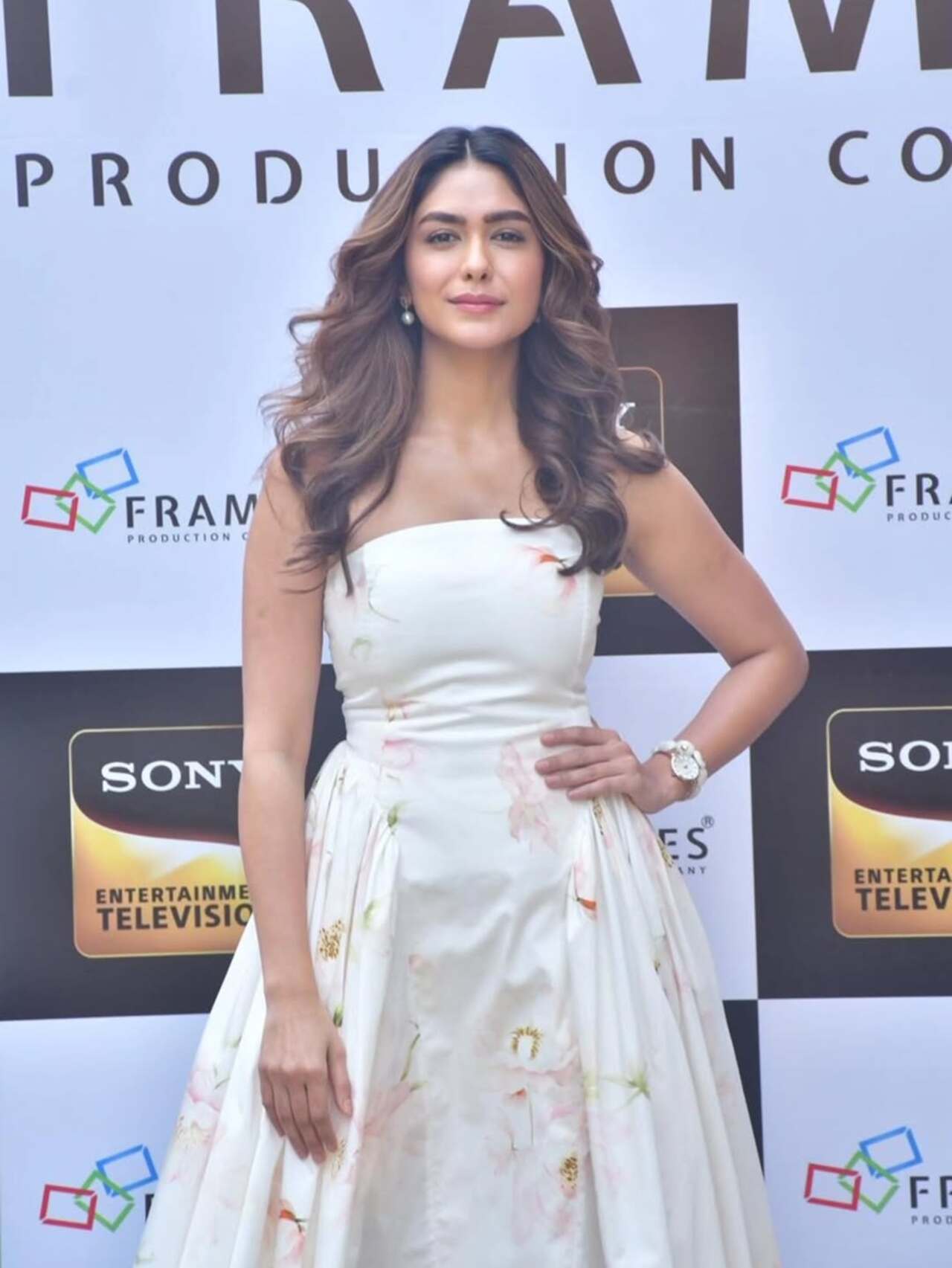 Mrunal looks elegant in a strapless white gown with soft floral prints. The fitted bodice and flowy skirt give her a classy, red-carpet-ready vibe.