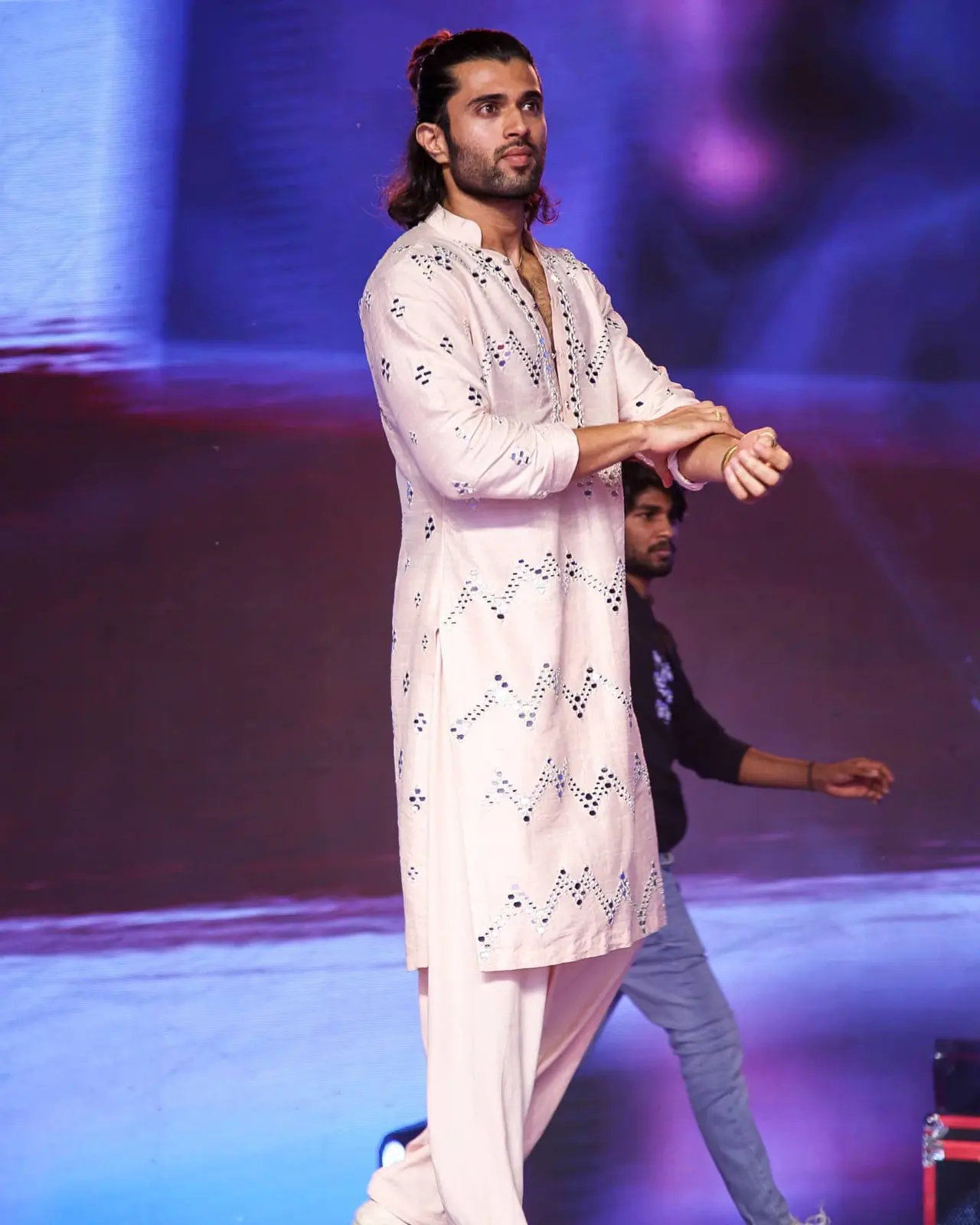 Vijay Deverakonda looks effortlessly stylish in a light pink kurta adorned with intricate mirror work, blending subtle elegance with festive charm.