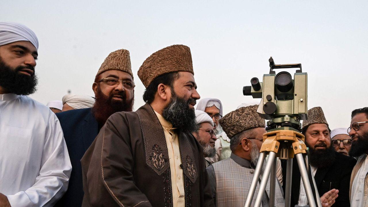In Peshawar, a religious scholar scans the sunset sky with a telescope, sighting the crescent moon that signals the start of the ninth month of the Islamic calendar