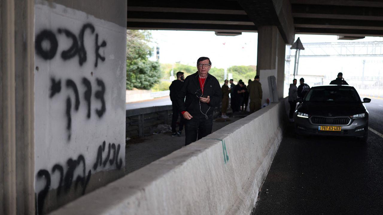 People run to take shelter under bridges after siren sounds while flashes and explosions light up the skies over northern Israel as air defense systems intercept incoming Iranian missiles hours after the initial strikes on Tehran