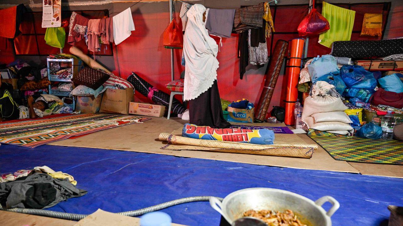 A woman in a temporary tent in Meurah Dua faces towards Mecca while praying, demonstrating resilience and faith amidst displacement after the floods in Pidie Jaya district