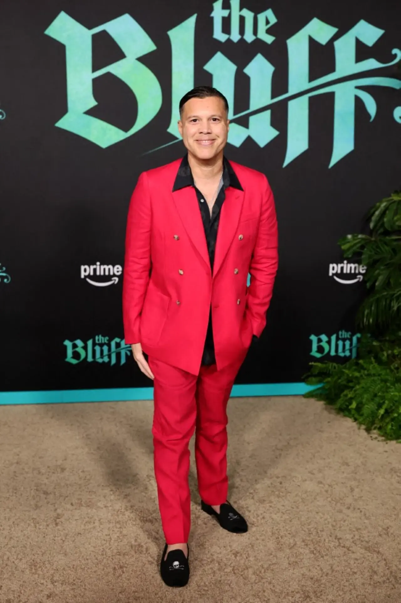 The director of The Bluff, Frank E. Flowers, showed up in a red suit paired with a black shirt at the premiere.