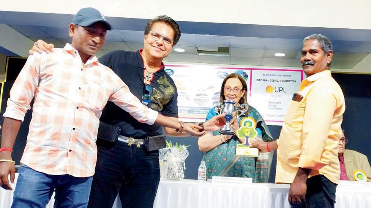 Douglas receiving the award from art historian Pheroza Godrej with his gardeners Bambam (l) and Susheel (extreme right)