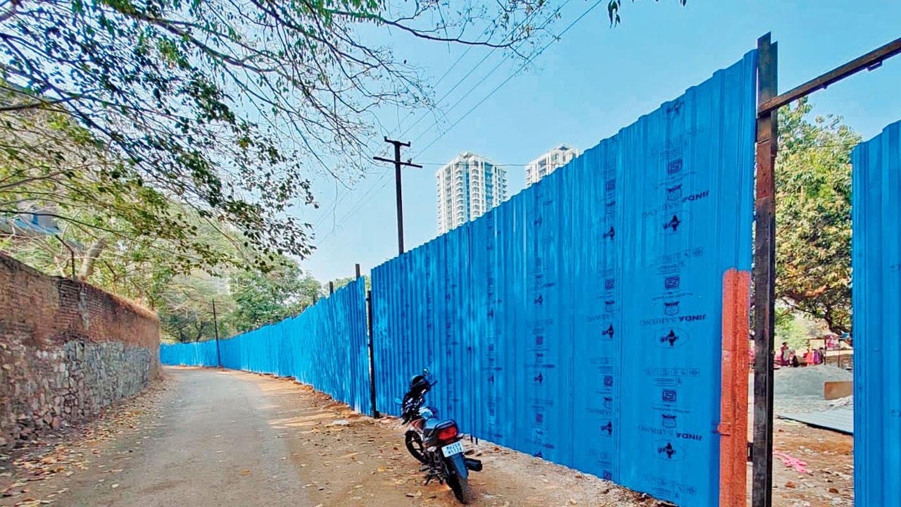 Tin-sheet fencing erected around the Manpada plot, which environmentalists claim may also violate ESZ norms