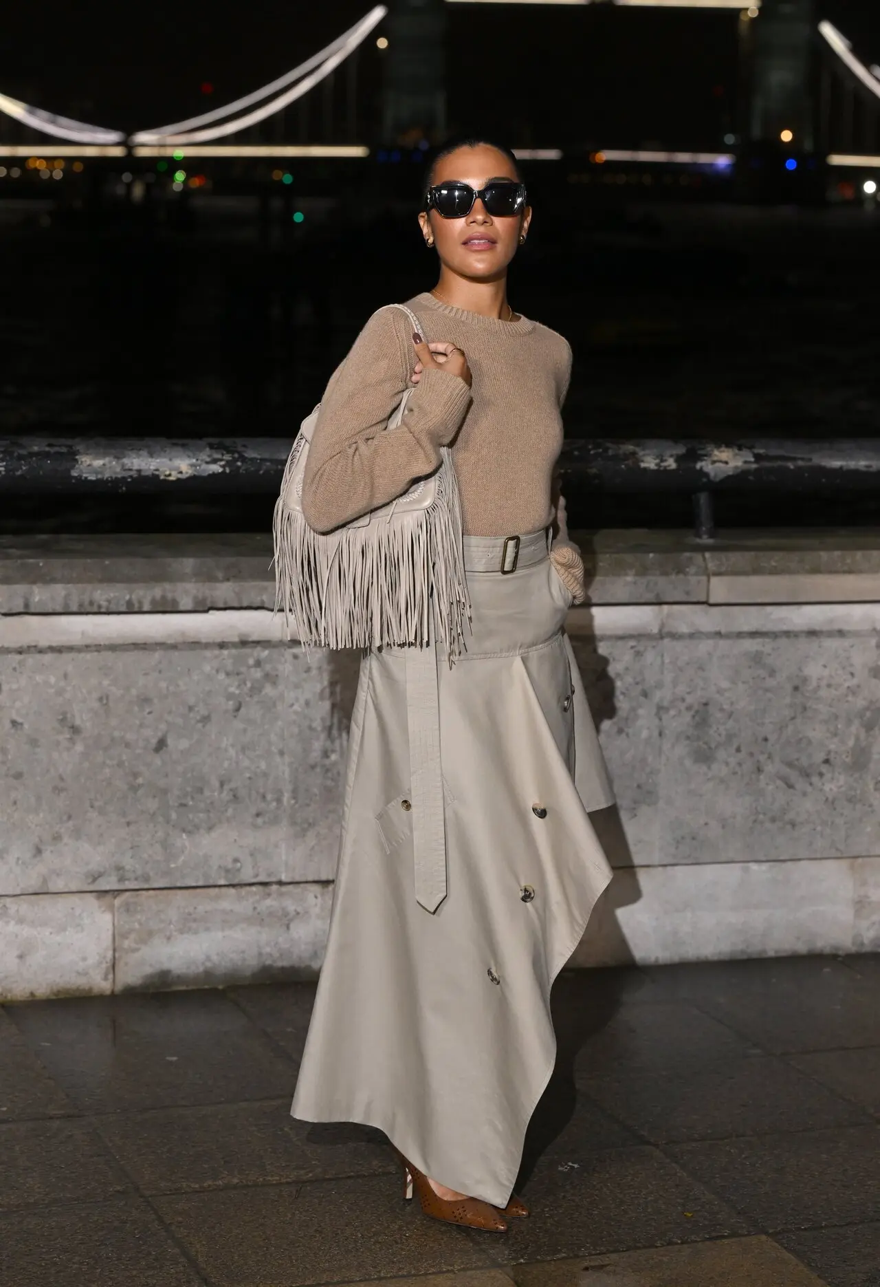 <p>Olivia Dean embraced understated elegance at London Fashion Week in a chic monochrome ensemble. She paired a fitted camel knit top with a high-waisted, asymmetrical beige midi skirt featuring button details and a statement belt. </p> <p>Olivia Dean embraced understated elegance at London Fashion Week in a chic monochrome ensemble. She paired a fitted camel knit top with a high-waisted, asymmetrical beige midi skirt featuring button details and a statement belt. </p>