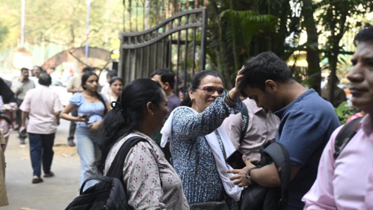 A student takes blessings from his elder before taking the exam.