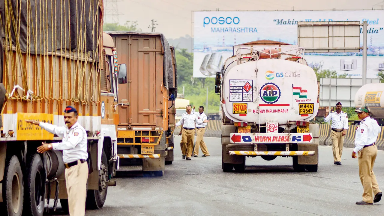 Police personnel halt heavy vehicles on the expressway