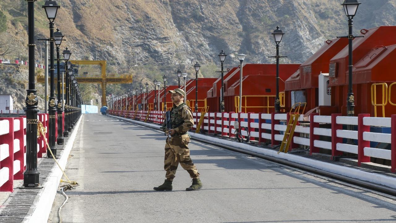 A security personnel patrols at the Salal Dam on the Chenab River. 