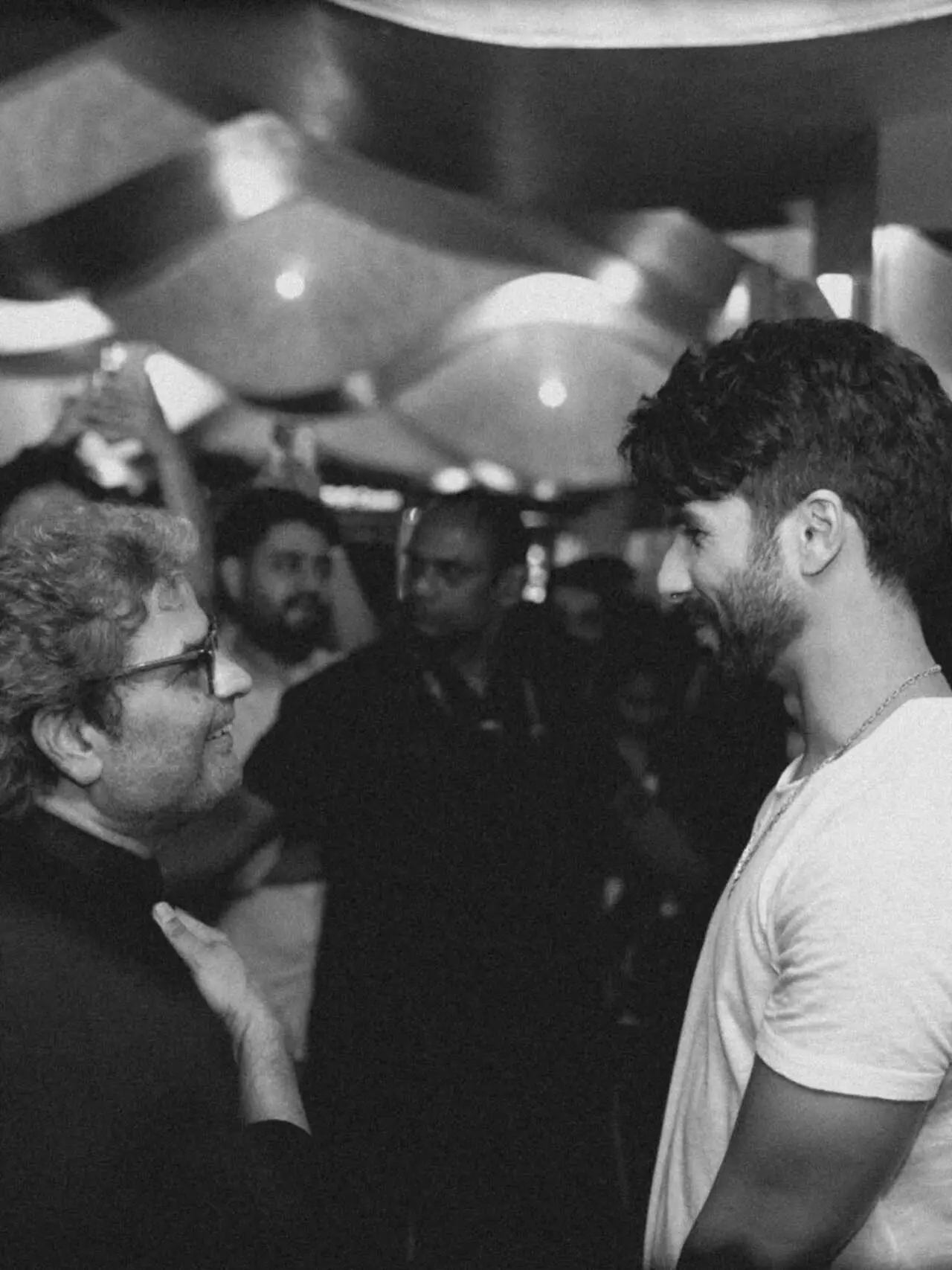 In the picture, Shahid Kapoor and Vishal Bhardwaj are seen engaged in a relaxed, candid conversation, smiling and sharing a light moment.