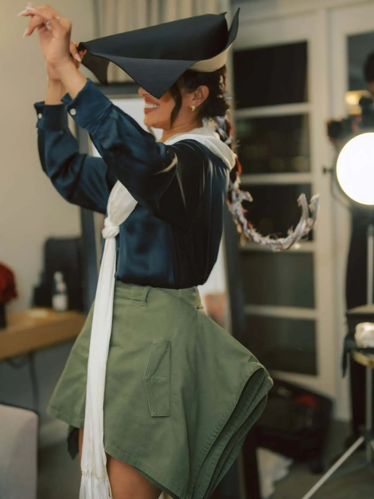 Priyanka Chopra Jonas mixes chic elegance with a playful edge in a glossy black satin shirt paired with an olive green structured skirt. 