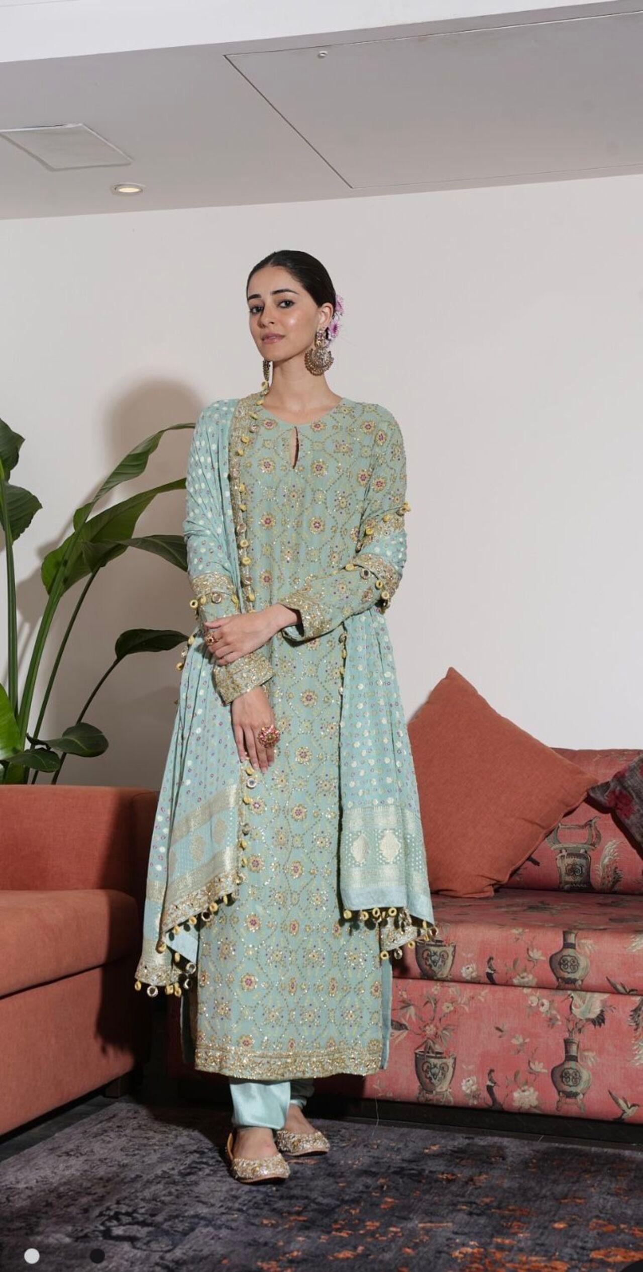 Ananya Panday keeps it traditional and regal inthis three-piece ensemble featuring a hand-embroidered kurta, a matching churidar, and a georgette bandhani dupatta with a threadwork floral border.