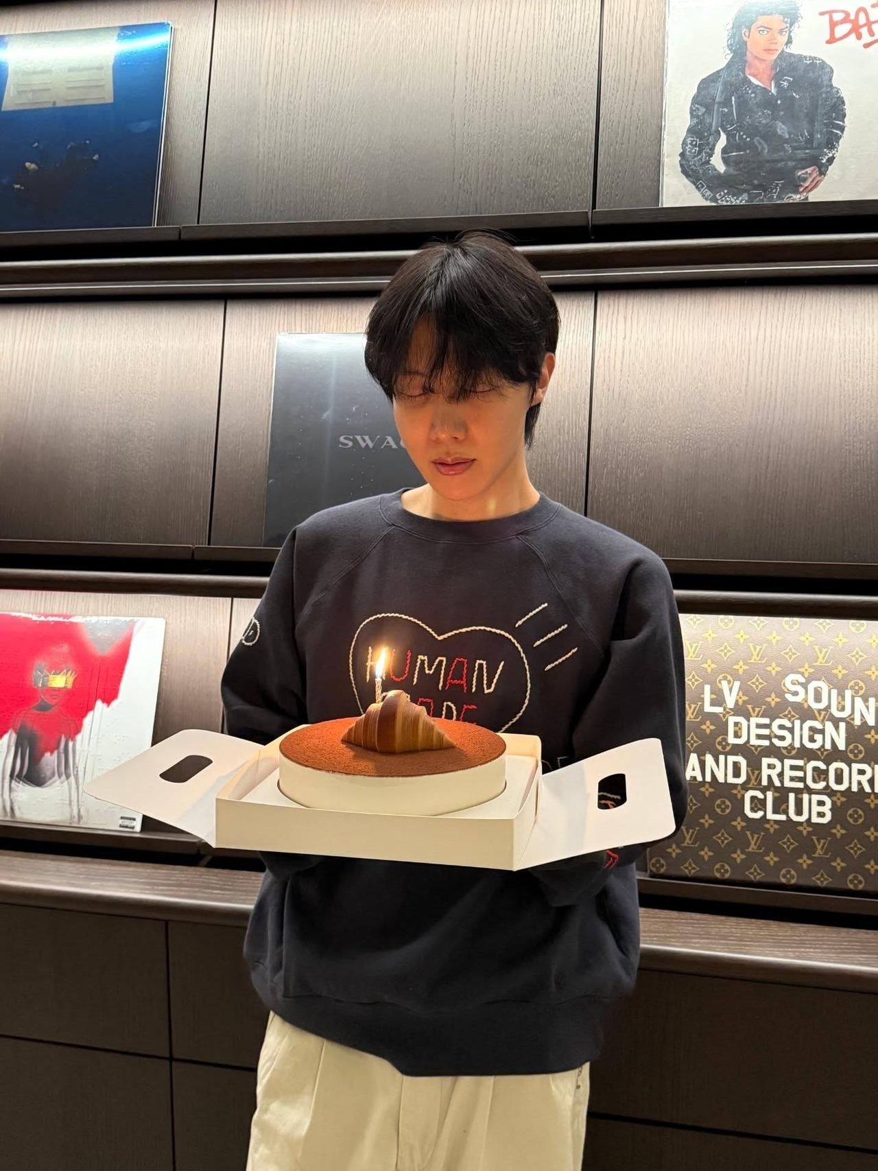 The birthday boy made a wish with his eyes closed before blowing out the candle and slicing his birthday cake.