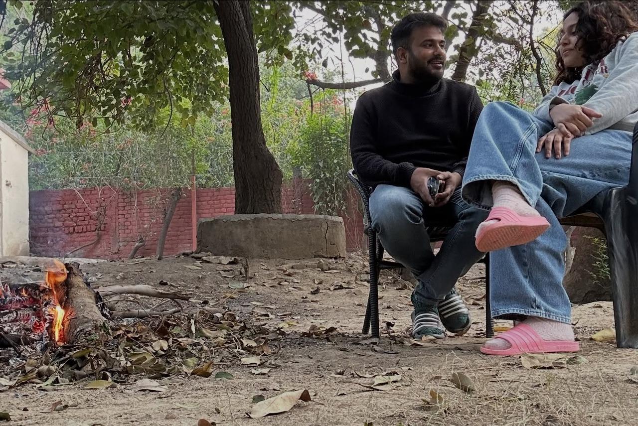 The couple is seen enjoying some quiet time by a bonfire surrounded by nature and each other's company in this picture.