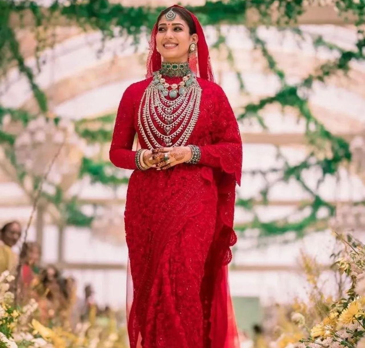 Nayanthara tied the knot with filmmaker Vignesh Shivam in 2022, in Chennai. She chose to wear a vermillion red, custom-designed saree by Monica Shah of Jade. She completed her look with a textured bun loaded with fresh jasmine flowers and a statement emerald maangtikka.
