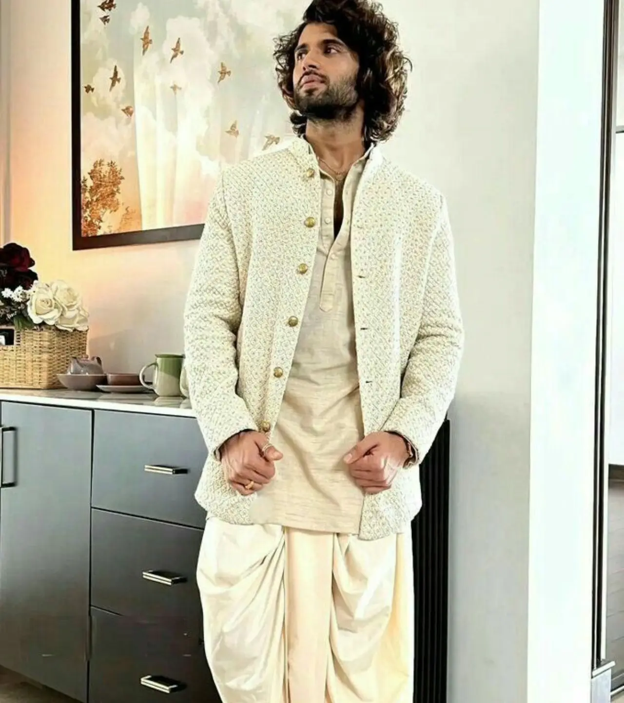 This look champions relaxed sophistication.The textured, off-white Bandi (Nehru jacket) is worn over a subtle-toned kurta, but the standout piece is the modern, draped dhoti pant.