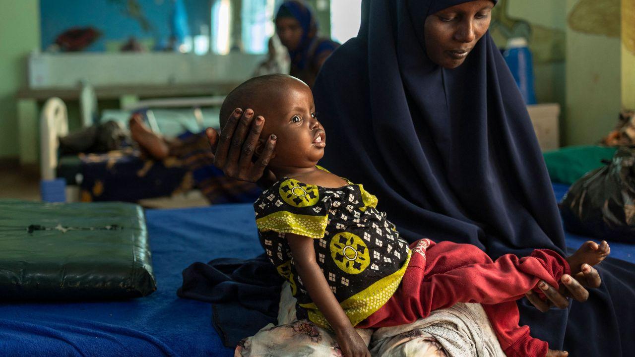 A mother holds her malnourished child at Banissa Hospital, highlighting how effects to livestock herds, which provide vital food source for pastoralist communities have left children and pregnant women at severe risk of acute malnutrition 