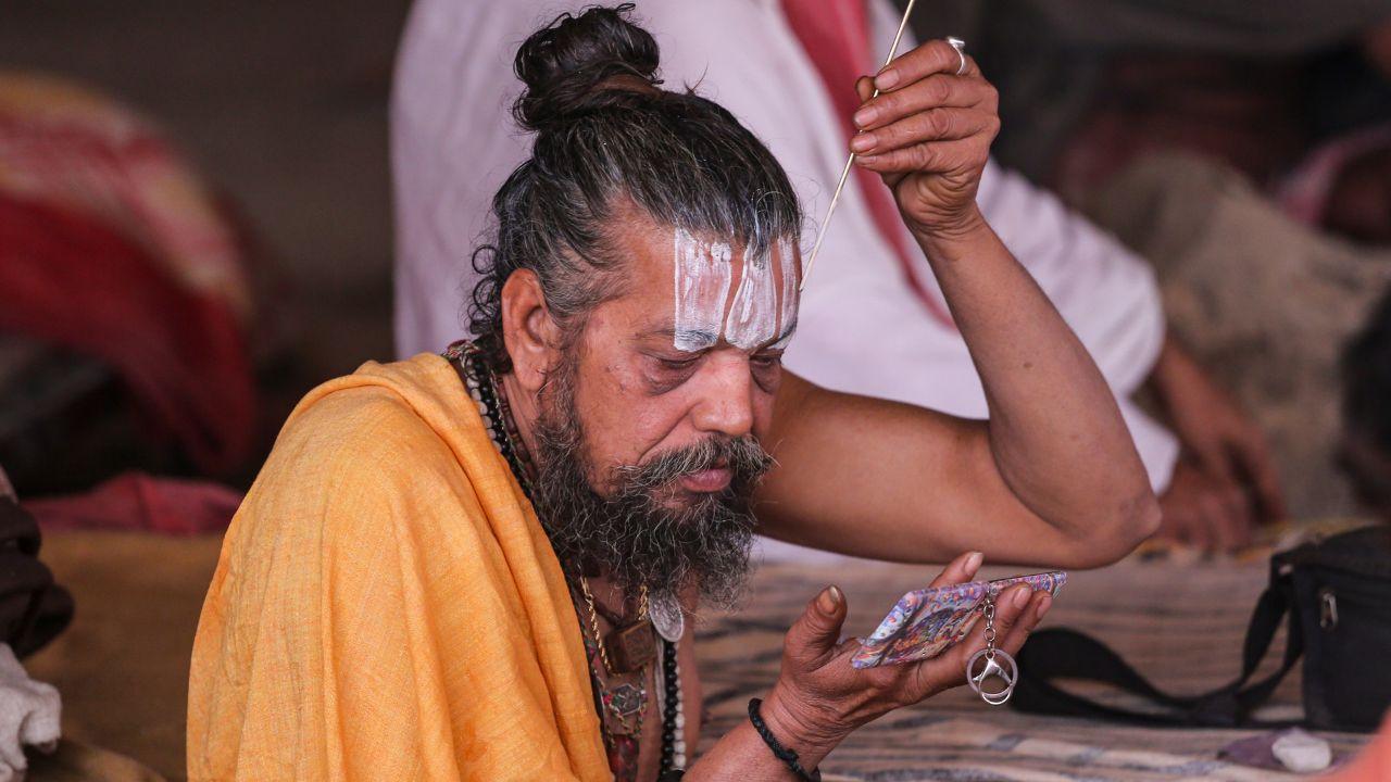 After emerging from the holy waters, a sadhu applies tilak, completing the morning ritual at Magh Mela