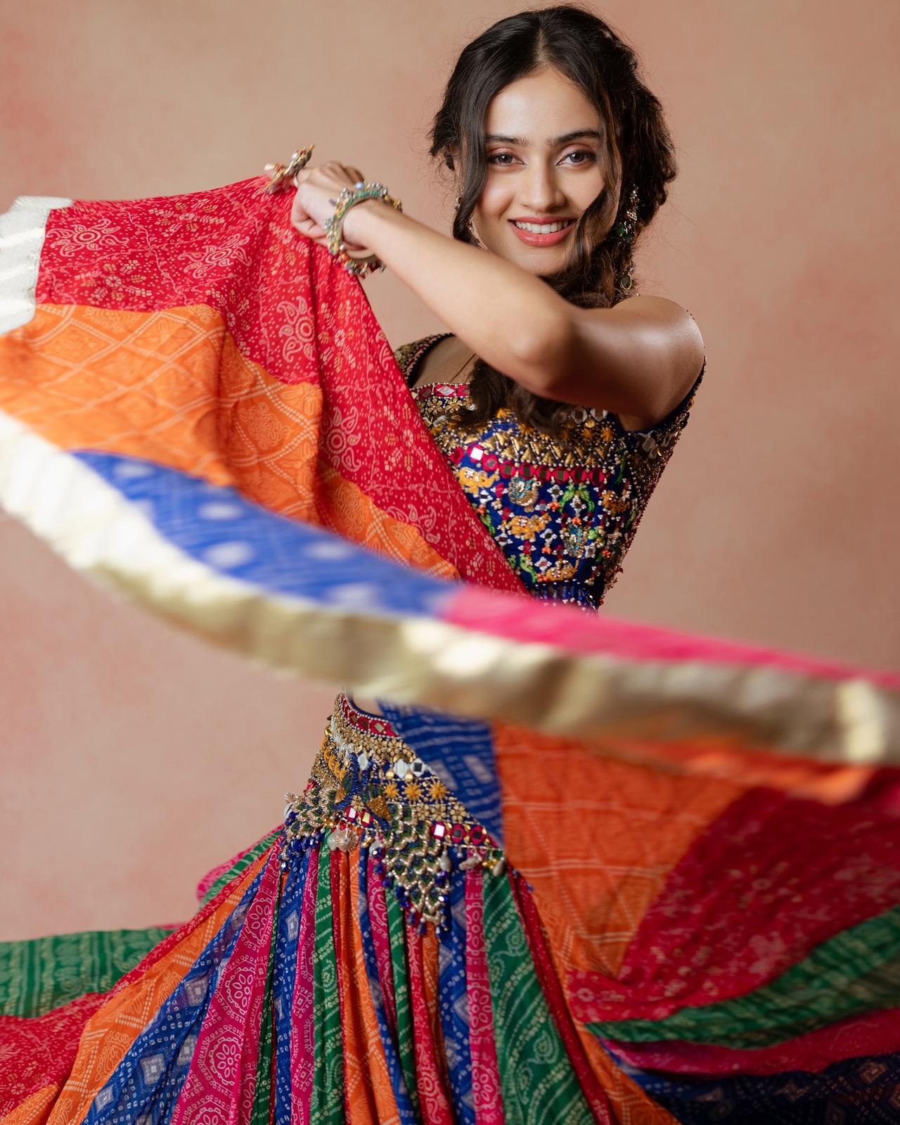 Janki looks vibrant and full of life in a stunning multicolour lehenga adorned with intricate mirror work and traditional bandhani patterns.