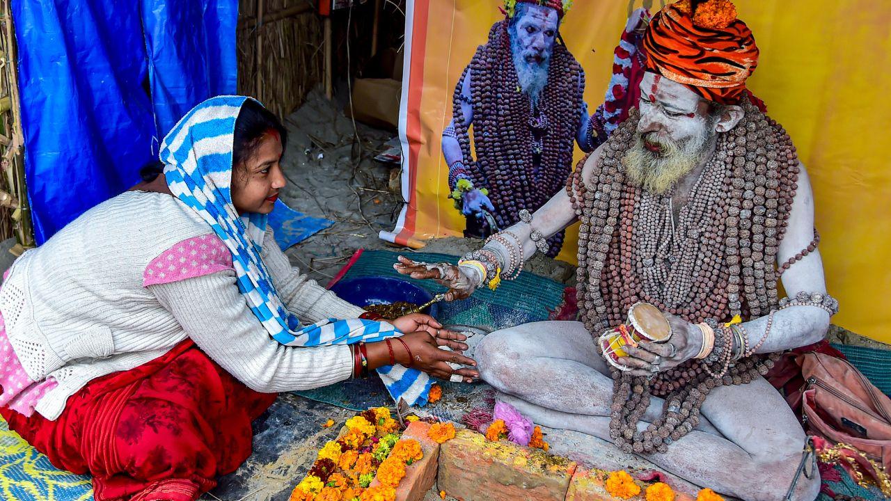 A woman seeks blessings from a 'Naga sadhu' of the Niranjani Akhara in Prayagraj, Uttar Pradesh